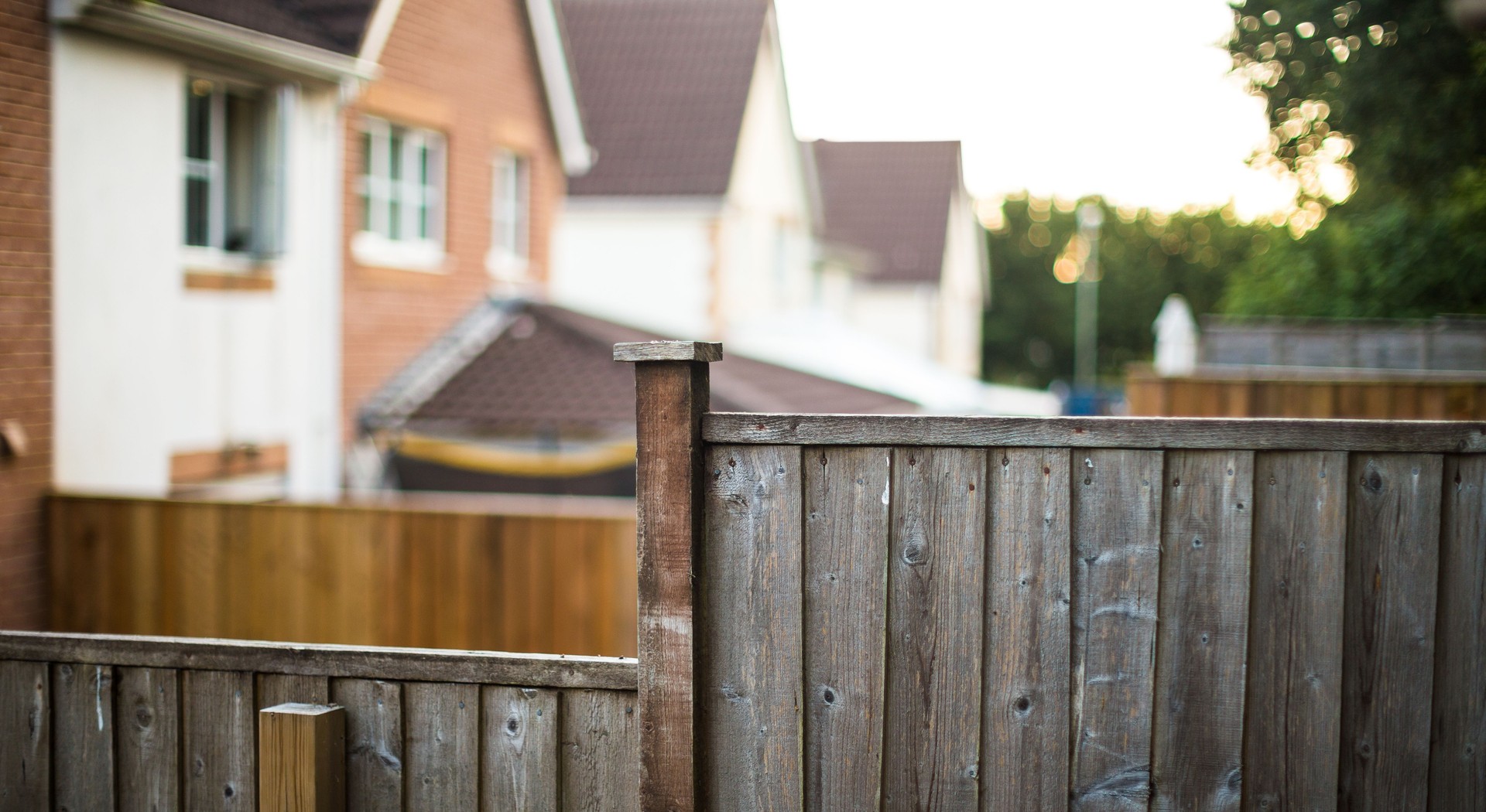 Wooden garden fence with new houses defocused in background